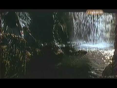 Woman disappears behind waterfall