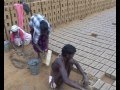 Trois personnes moulent des briques en plein soleil