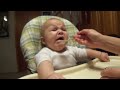 Baby makes funny faces while eating apples