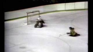 Bobby Clarke scores a goal sliding on the ice