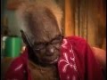 Una mujer peinandola a una mujer anciana.