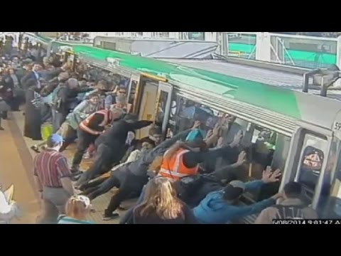 Mind the gap: Commuters push train to save trapped image