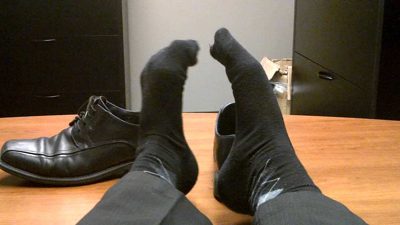 Taking off my well worn work shoes, revealing my thin socked feet