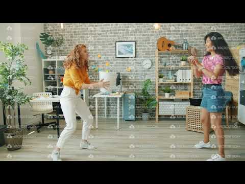 Young ladies throwing paper balls in basket in office enjoying funny game