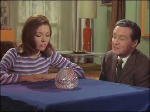 Youtube video - Emma and Steed gaze into a crystal ball, she sees a sign that says ‘Tune in again next week’ while he sees something more salacious