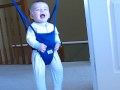 Funny baby laughing in jolly jumper