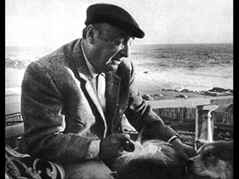 Pablo Neruda in una foto in bianco e nero siede su una sedia avanti alla sua casa in riva al mare