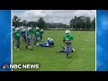 Elementary school football teams come together to set up special play for teammate