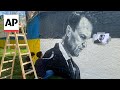 Artists spray-paint portraits of Alexei Navalny behind Soviet monument in Vienna