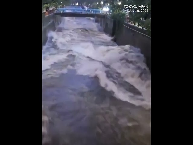 Floodwater gushes down Tokyo's Meguro River