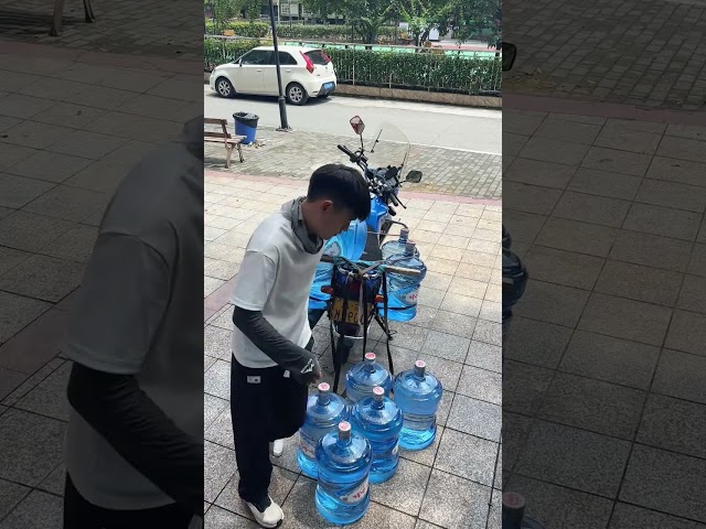 Loading barrels of drinking water on a motorcycle