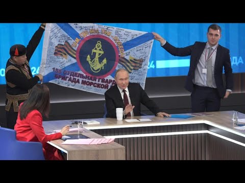 Putin poses for photo with flag signed by frontline soldiers | AFP