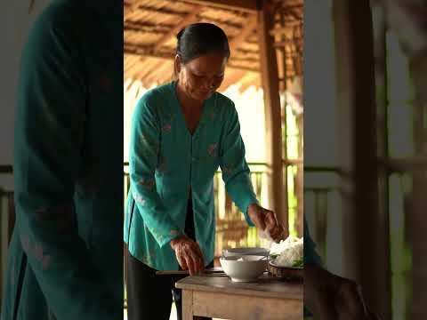 Người mẹ dọn cơm trong căn nhà tranh