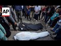 Relatives carry shrouded remains of victims killed in Israeli airstrike out of hospital morgue
