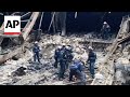 Rescuers clear rubble from Moscow Hall, while mourners bring flowers for victims