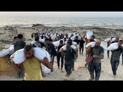 Palestinians carry bags of flour in northern Gaza Strip | AFP
