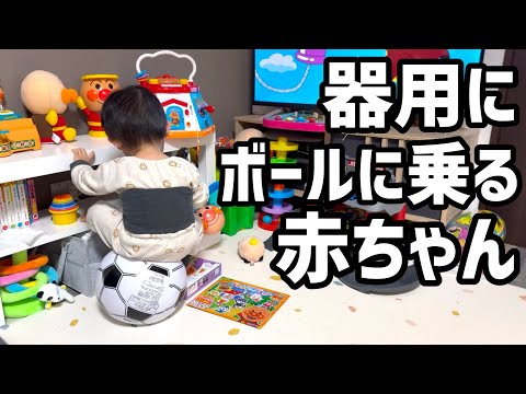 器用にボールに乗りつつテレビを楽しむ1歳4ヶ月の赤ちゃん