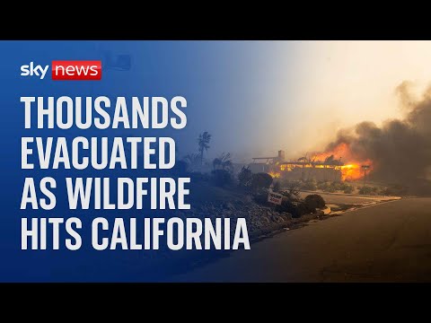 Thousands evacuated as powerful wildfire burns homes in Southern California