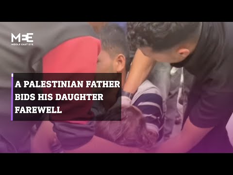 A Palestinian father bids his young girl farewell after she is killed by an Israeli bombing