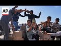 Palestinians pick up aid boxes from newly opened aid distribution center in Rafah
