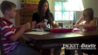 Corinne Mullen, 14-year-old Beaufort, S.C., resident and crafter, demonstrates how to make an owl magnet or pin using a soda can tab, sequins, rhinestones and feathers.