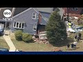 Driver trapped after dump truck slams into home