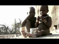 Dos niños sentados en el suelo comiendo.
