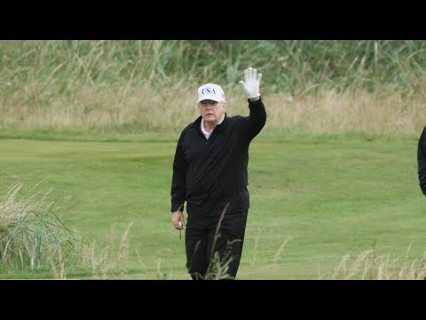 US President Donald Trump waves to media during a game of golf at his Turnberry resort | AFP