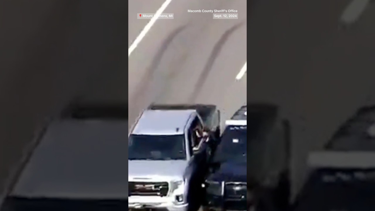 Police climb through a car window to rescue driver during medical emergency