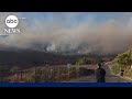 Residents flee wildfires in West, storms slam Northeast