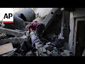 Boy searches through mass of concrete rubble after deadly Israeli strike on central Gaza