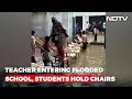 Teacher enters flooded school as students hold chairs, video goes viral